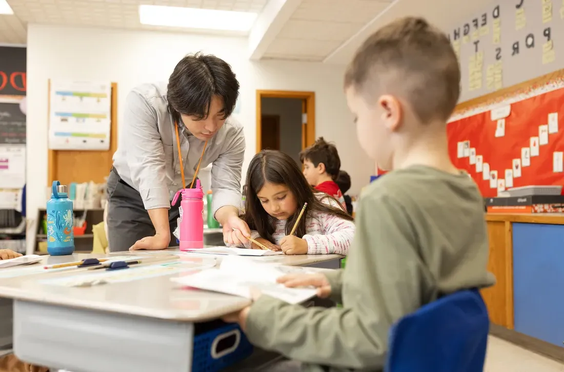 Student teacher teaching children in a classroom.